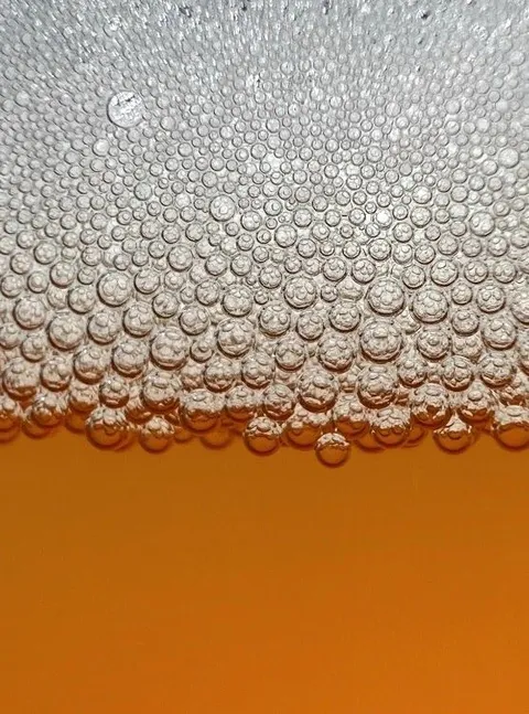 Belletjes en schuim op een glas bier van dichtbij