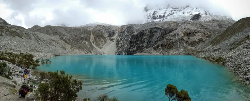 Panorama van het turquoise meer Laguna 69 in Peru onder besneeuwde bergtoppen